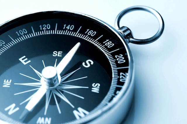 A hand-held compass pointing approximately north